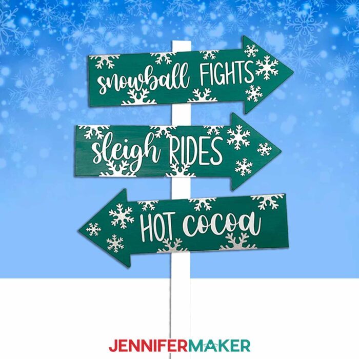 Make a custom family sign post with JenniferMaker's tutorial! A signpost with three arrows reading "Snowball Fights," "Sleigh Rides," and "Hot Cocoa" stand against a snowy background.