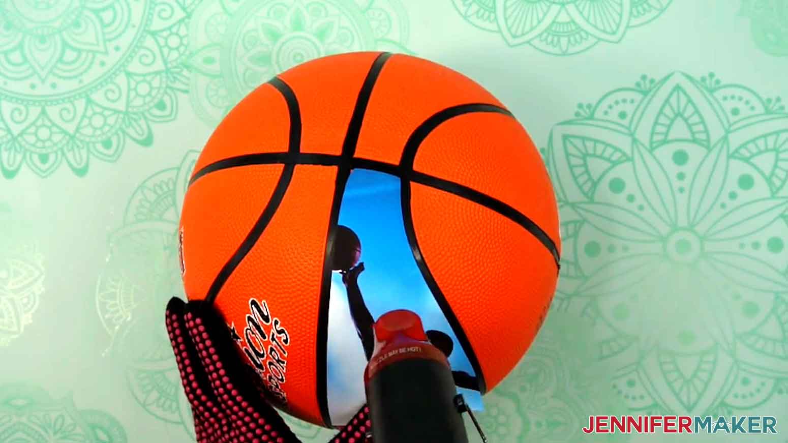 Apply heat down the center of the basketball to adhere the photo panel to the basketball.