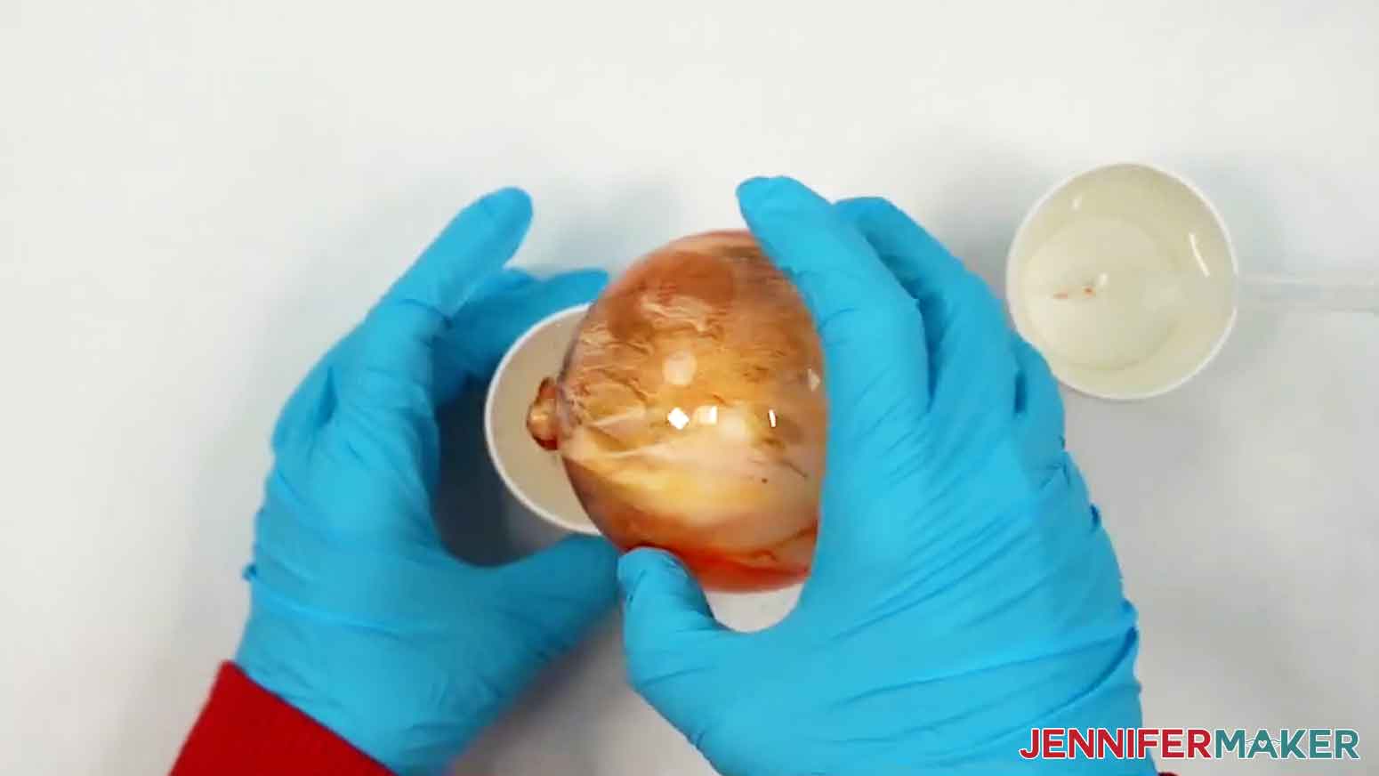 Turn the ornament so the hole is facing down, and place it inside of a paper cup to let any excess paint drip out.