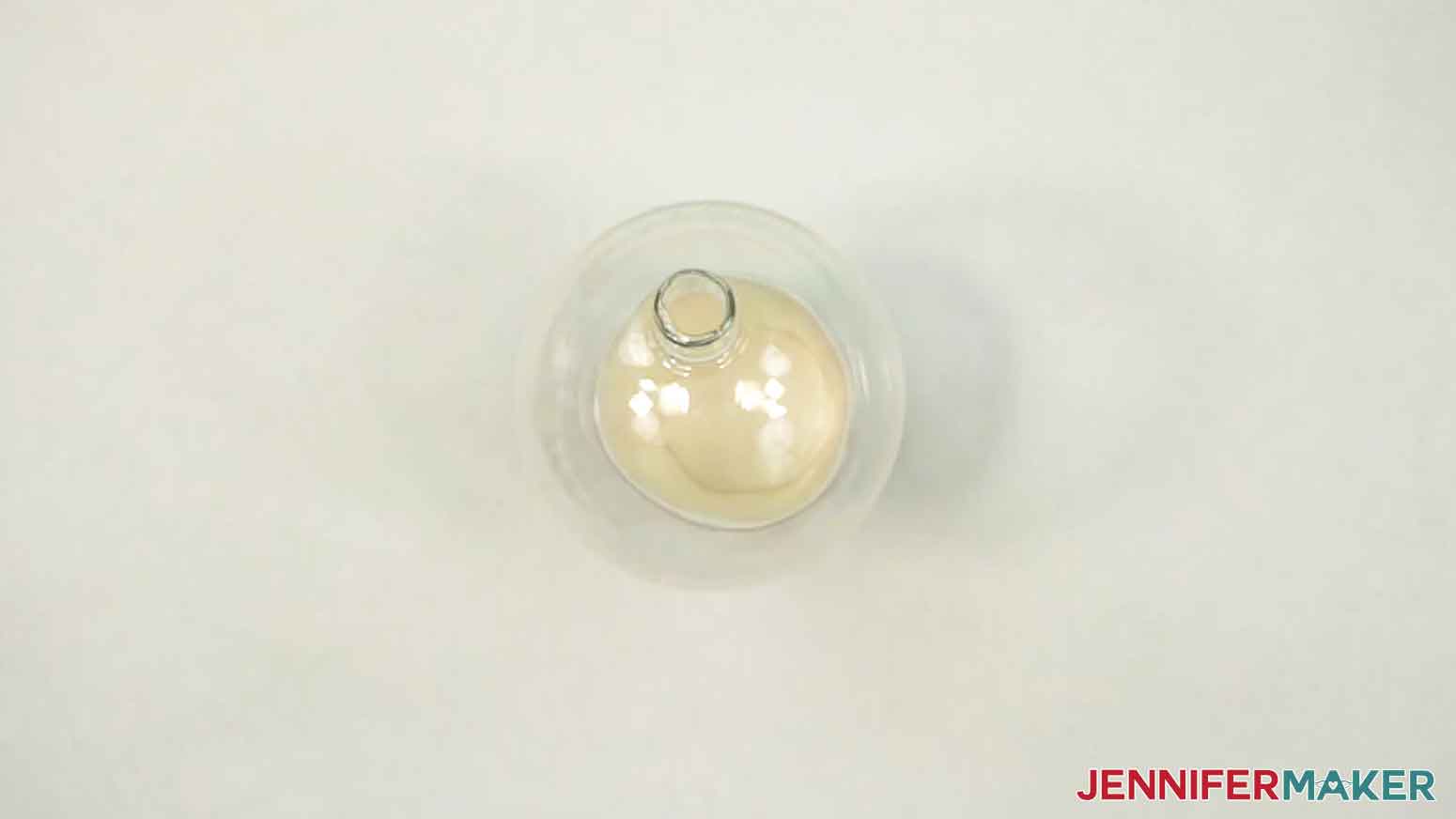 Place the ornament on a paper cup to hold it steady with the hole facing up.