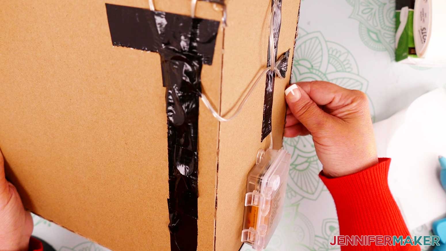 Secure the light cords to the outside of the diy book nook box with duct tape
