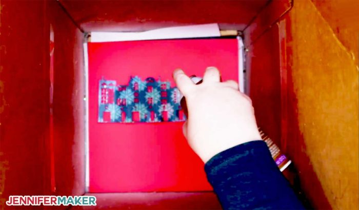 Applying spray adhesive to my DIY Christmas Countdown in a spray box