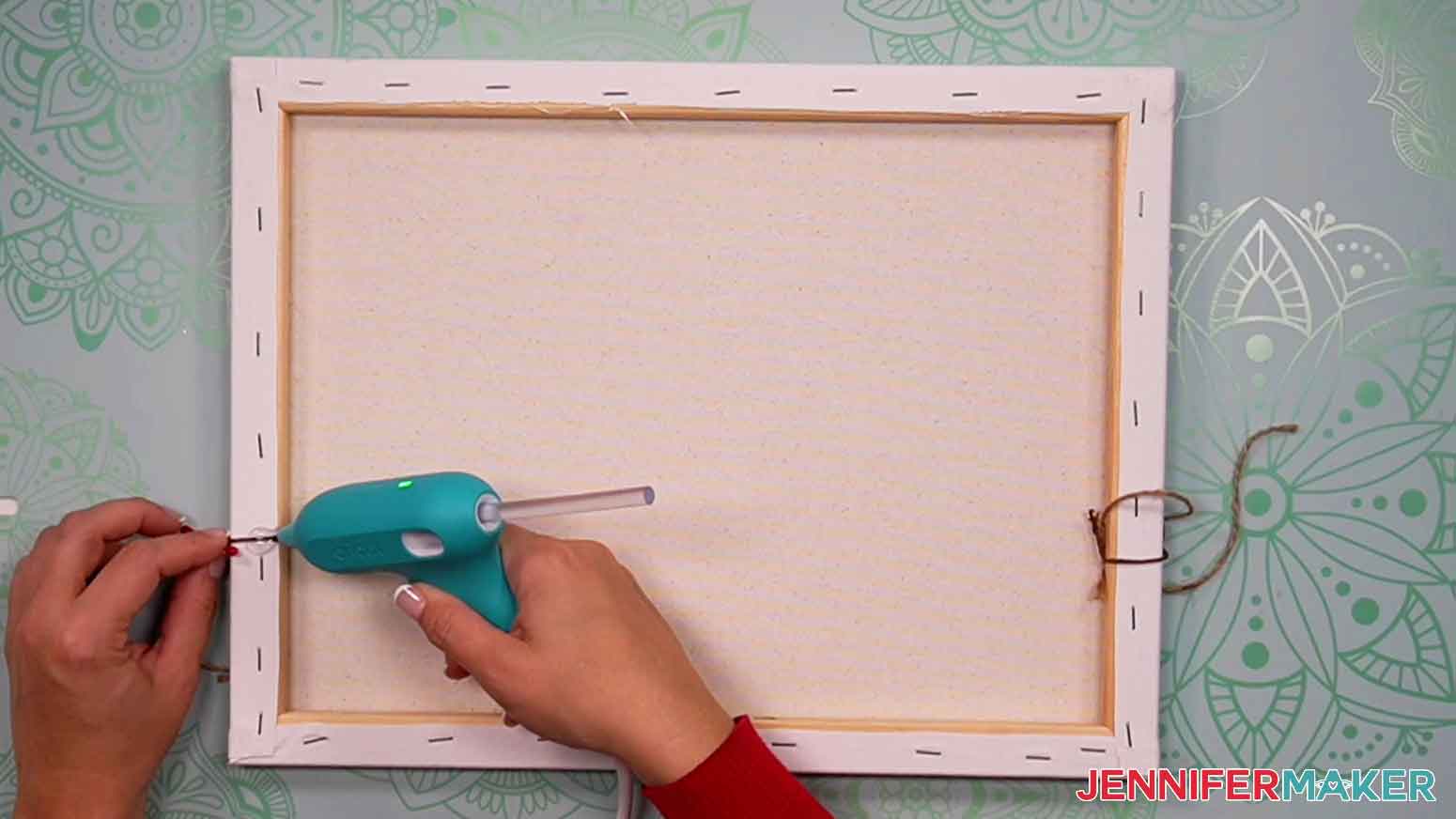 Use hot glue to hold the ends of the berry garland in place on the back of the canvas.