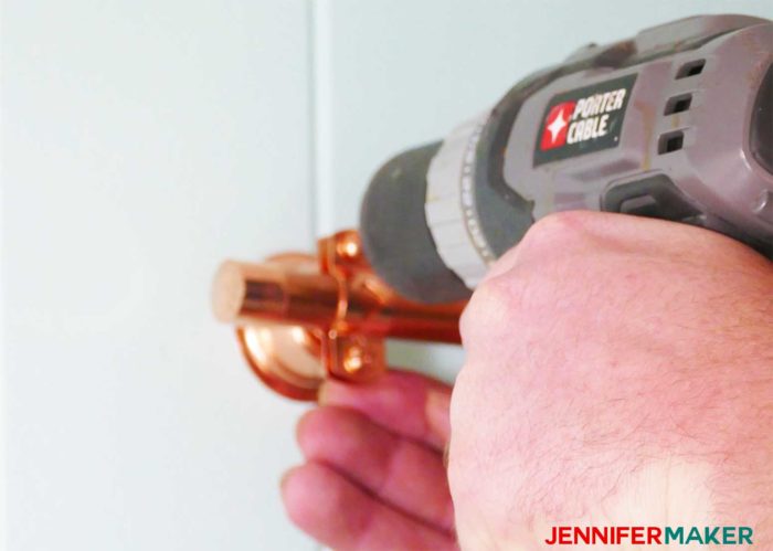 Securing the copper pipe in the copper bell hanger clamp to make the DIY copper pipe curtain rods