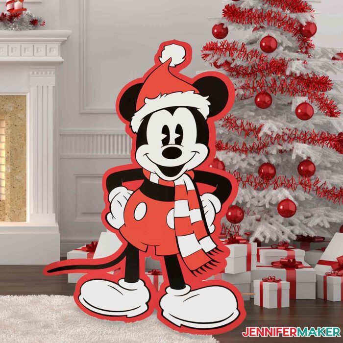 DIY cut out cartoon vintage Mickey Mouse wearing Santa hat by a Christmas tree standing almost as tall as the fireplace.