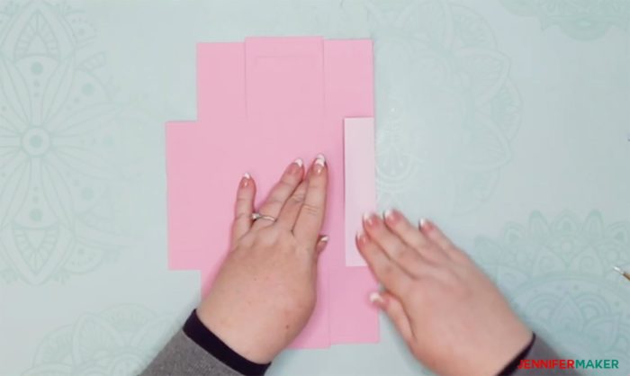 Folding a pink piece of cardstock cut into a DIY drawer divider box