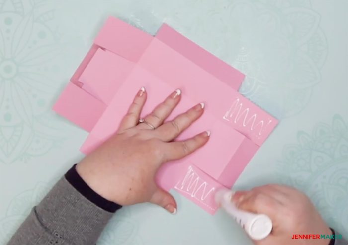 Glueing the sides on a pink piece of cut cardstock to make a DIY drawer divider