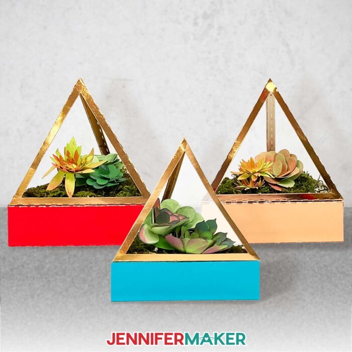 Learn how to make a DIY faux terrarium with JenniferMaker's tutorial! Three small faux terrariums made with metallic and multicolored cardstock, filled with a variety of hand-inked cardstock succulents.