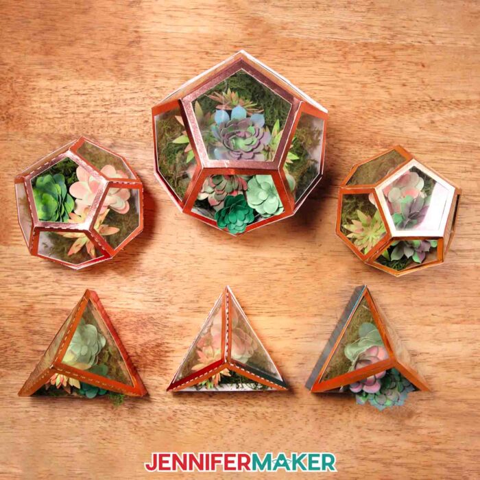 Learn how to make a DIY faux terrarium with JenniferMaker's tutorial! Six small faux terrariums made with metallic and multicolored cardstock, filled with a variety of hand-inked cardstock succulents.