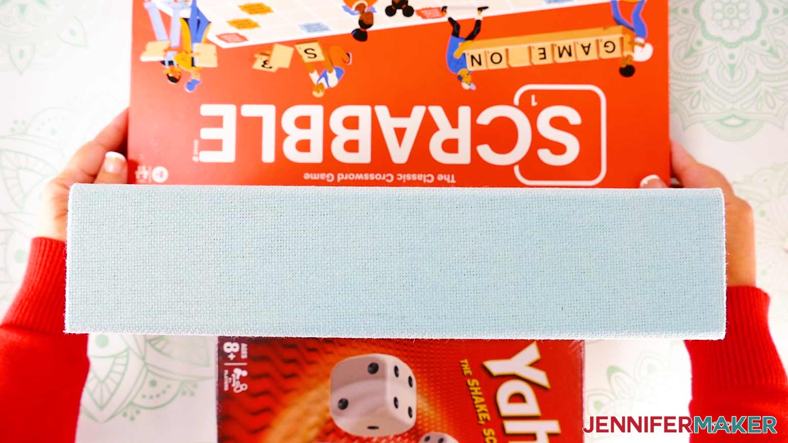 Place heavy objects on either side of the painted board game box before pressing the spine decal