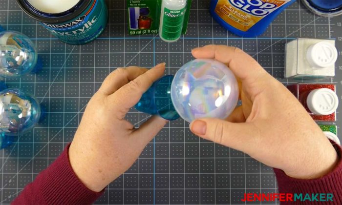 Let the adhesive from the ornament drain into a cup to make DIY glitter ornaments