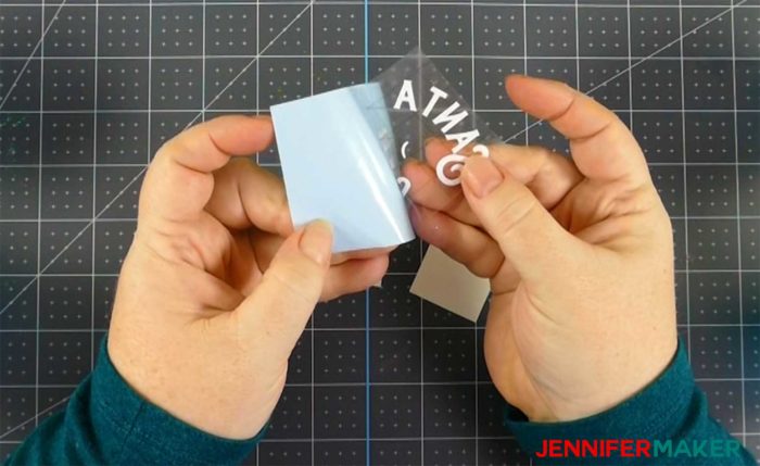 Removing the backing from a white layer of vinyl for the DIY glitter ornament decal