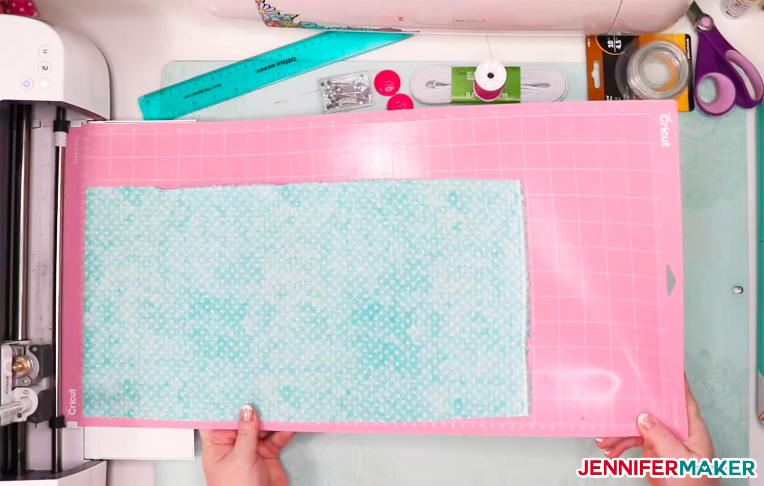 Loading fabric on a pink FabricGrip mat in to a Cricut Maker to make DIY headbands with buttons for masks