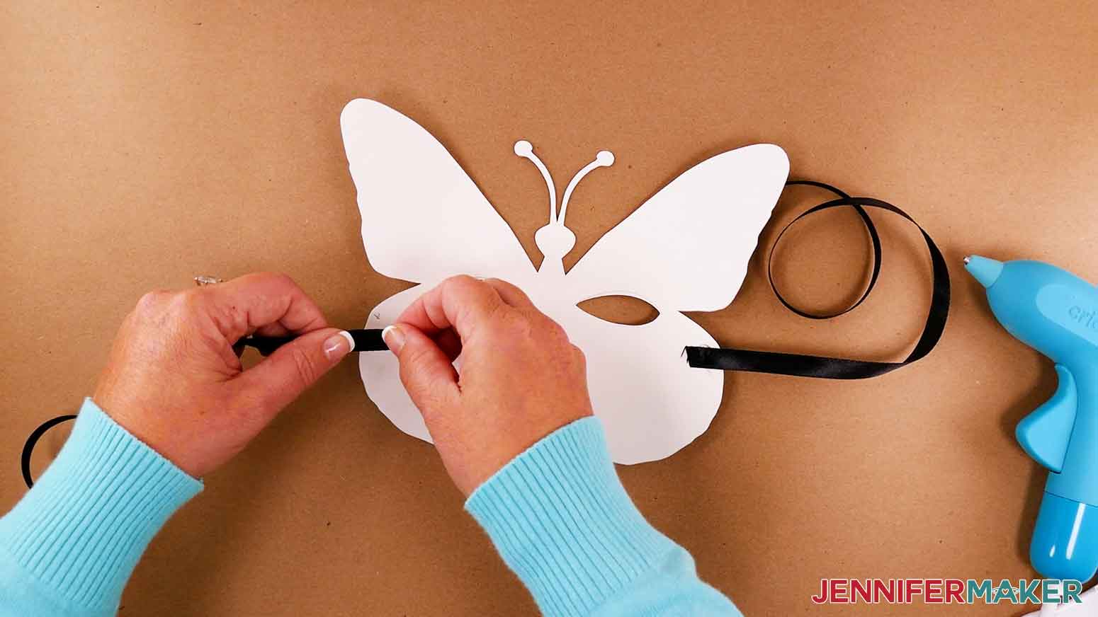 Use a small amount of hot glue to attach ribbon to the back side of butterfly masquerade mask.