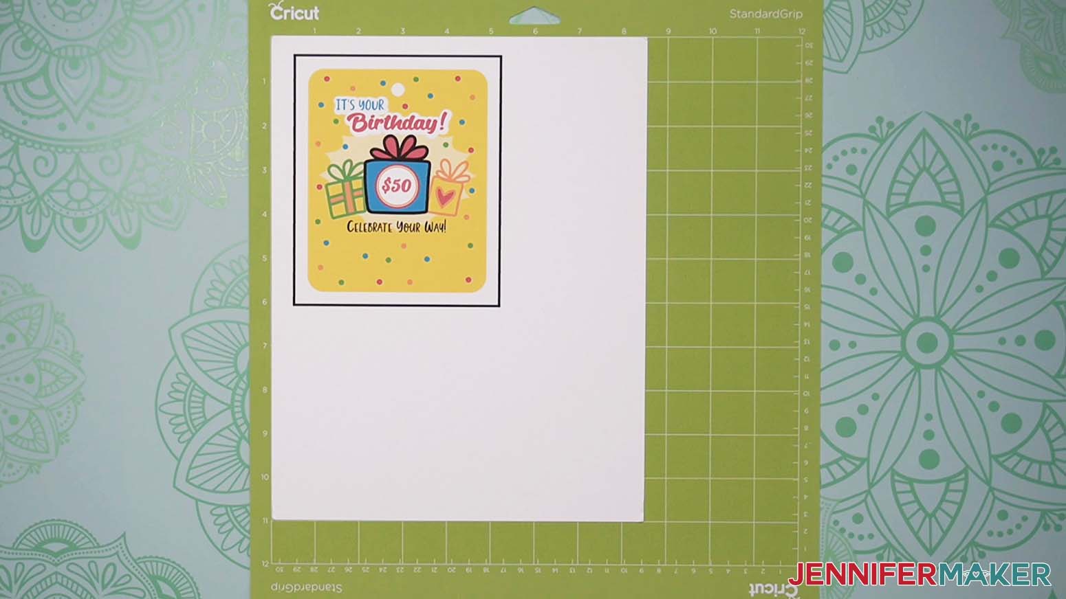 The printed birthday design on a piece of cardstock is adhered to a green machine mat for the DIY money holders project