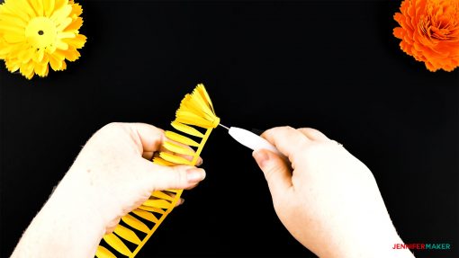 Rolling up the bud petals of the DIY paper marigold