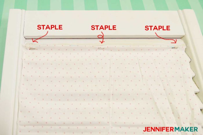 Start by stapling one end of the fabric to the bottom of the slat in three spots to make a DIY paper organizer