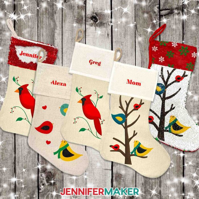 Create a DIY personalized Christmas stocking with sublimation with JenniferMaker's tutorial! Five varying personalized sublimated Christmas stockings lie on a distressed wood surface. They're made from different materials and decorated with different bird designs and names like "Jennifer," "Alexa," "Greg," and "Mom."