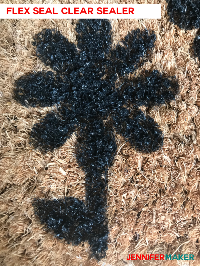 Close up of a DIY personalized door mat made of coir, painted with exterior house paint, and sealed with Flex Seal Clear Spray