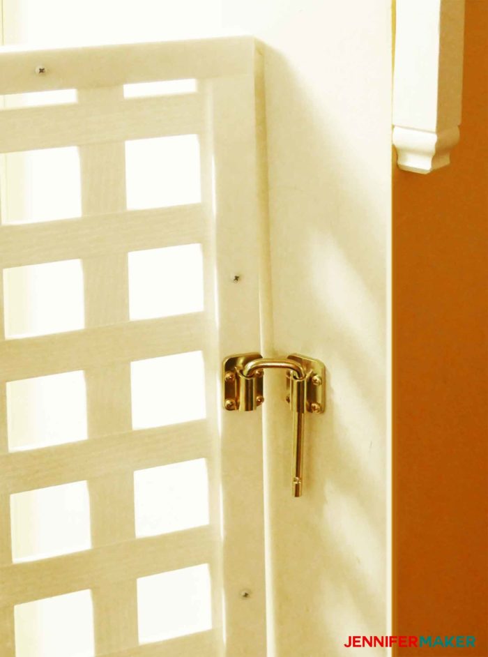 Sliding door latch attached to a wall to secure a DIY pet gate 