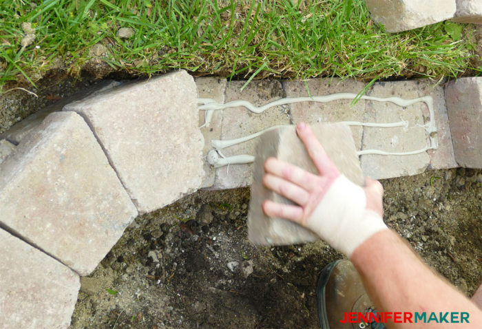 Placing bricks on the retaining wall offset from one another for a stronger wall