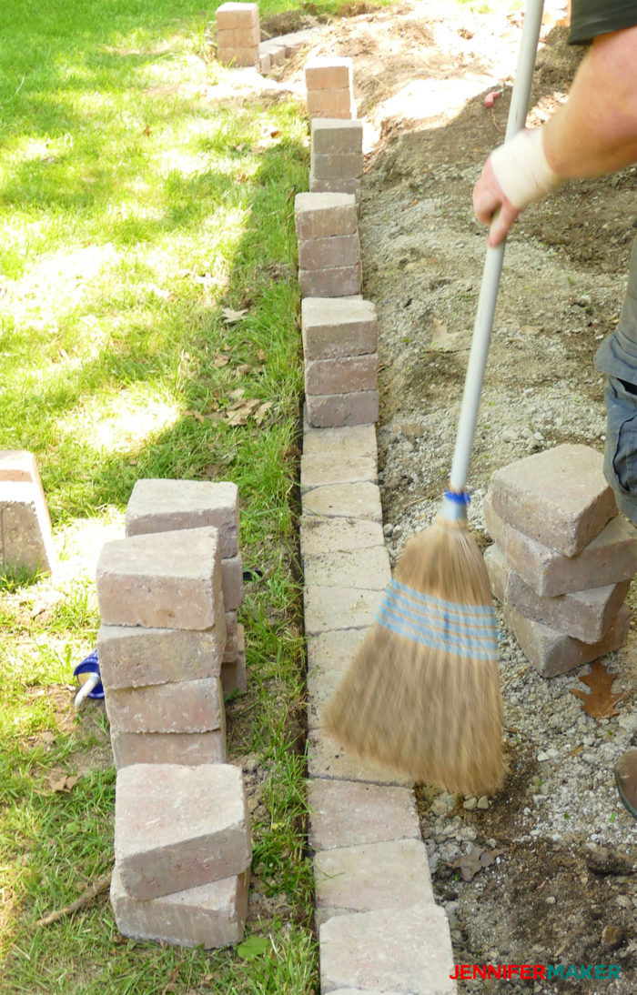 Removing dust and debris with a broom to make a retaining wall