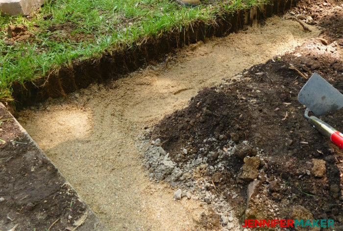 Put leveling sand on top of your gravel base to make a good foundation for your DIY retaining wall