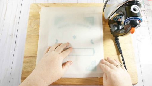 Lay a piece of parchment paper over your HTV plastic backing before ironing on your DIY Santa Sack design