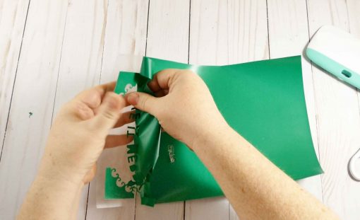 Remove the excess vinyl from the plastic backing for your diy Santa Sack design