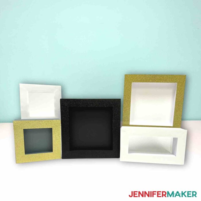 Three DIY Shadow Box frames made from gold cardstock, black Kraft board, and white cardstock