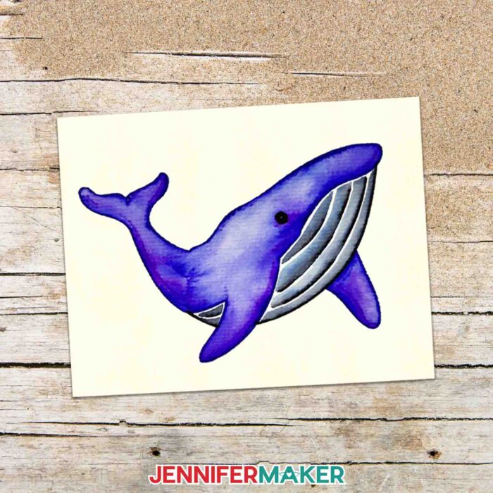 A DIY watercolor card featuring a whale made with Cricut watercolor markers.