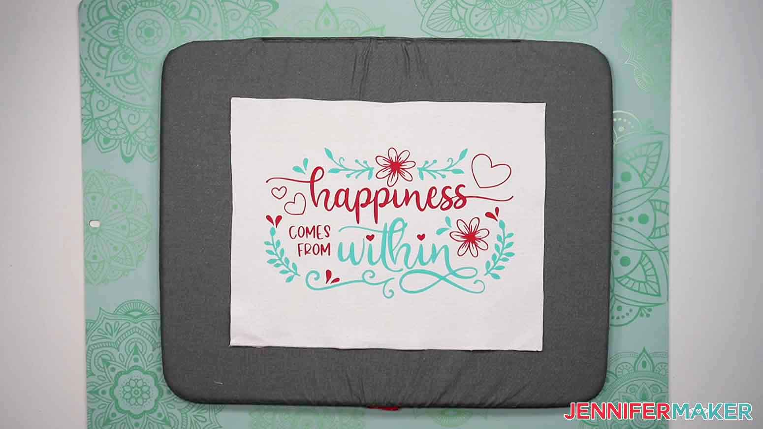 Layered teal and red happiness design pressed on plain canvas.