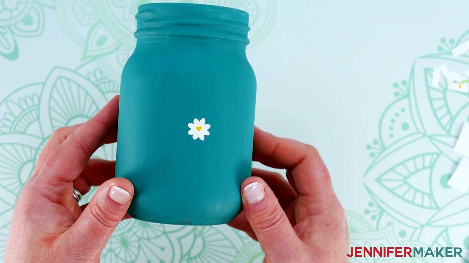 Dollar Tree Cricut Projects of painted canning jar with white flower applied.