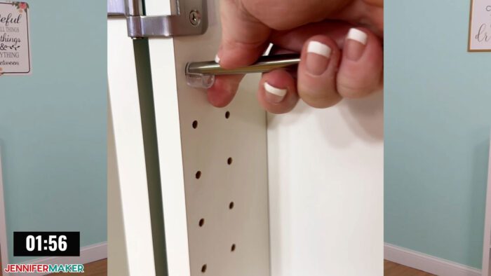 Jennifer Maker installing supported pegs for hanging cups inside her DreamBox 2 craft storage furniture.