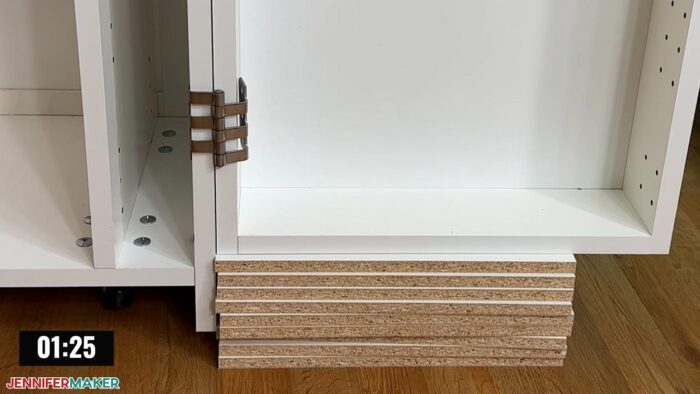 The swing door of a DreamBox 2 craft storage solution supported by stacked shelving pieces while it's being assembled to keep the door straight.