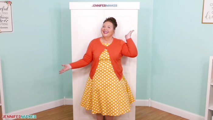 Jennifer Maker standing happily in her craft room in front of her closed DreamBox 2 craft storage furniture.