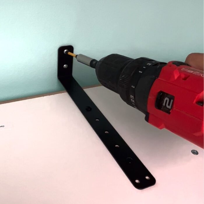 Jennifer Maker demonstrating how to install the safety kit brackets and mount the Dreambox on the wall.