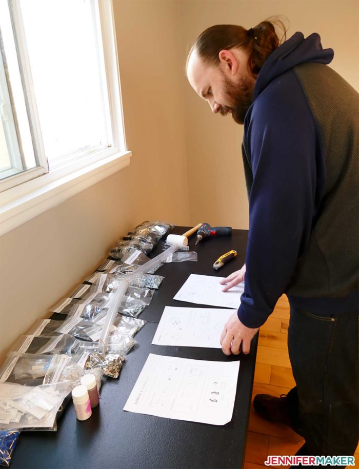 Greg inspecting the DreamBox parts and instructions on a table in his room