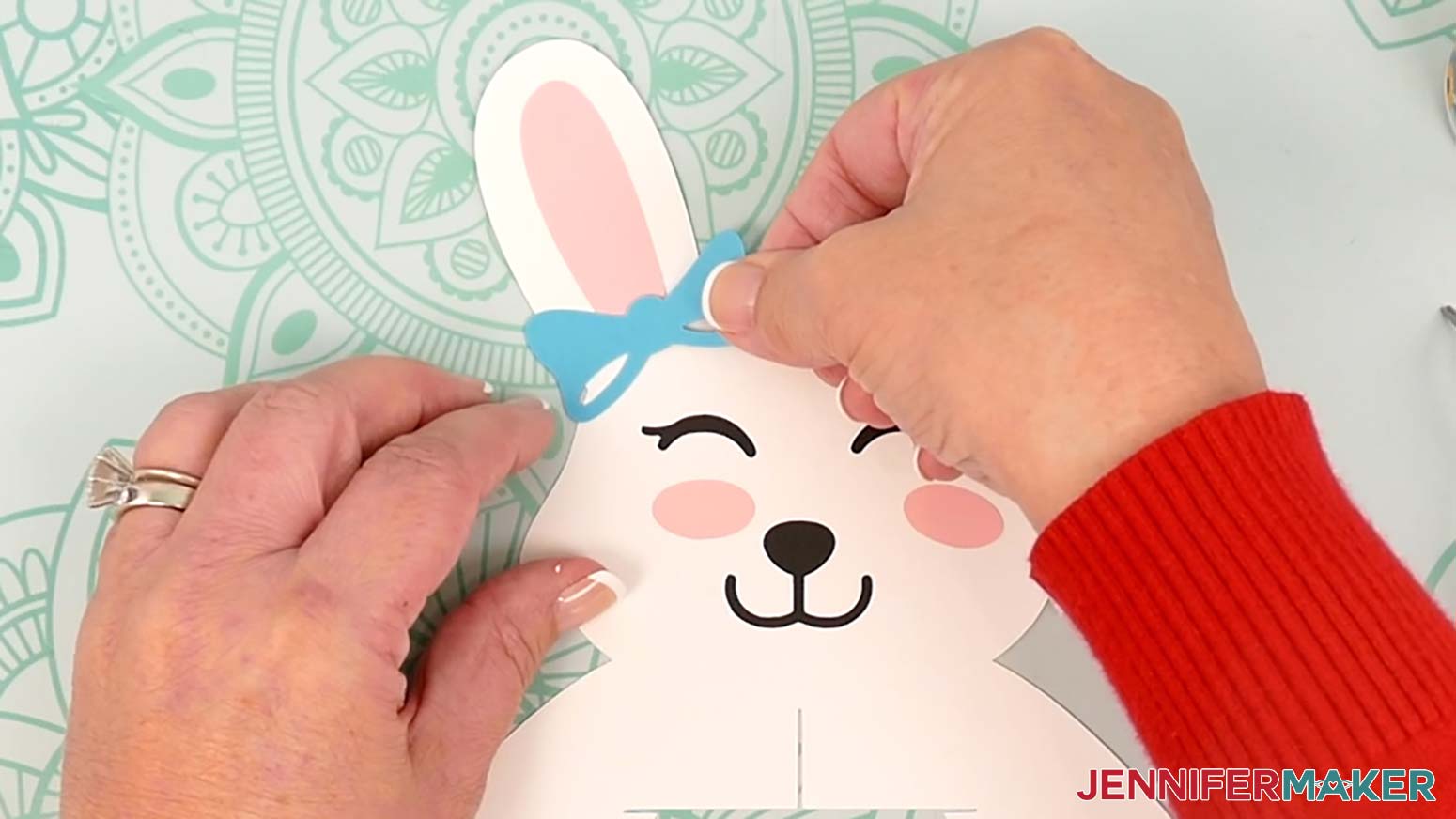 Attach the bow to the bunny lantern's head with the cutouts facing down and the top slightly covering the left ear piece.