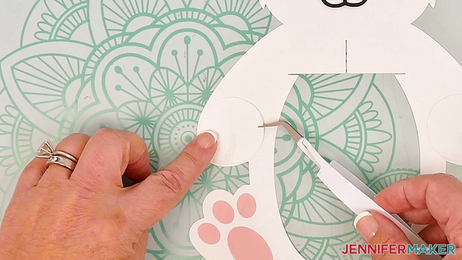 Adhere the left paw for the bunny lantern to the body frame so the outer curve matches the curve of the left arm.