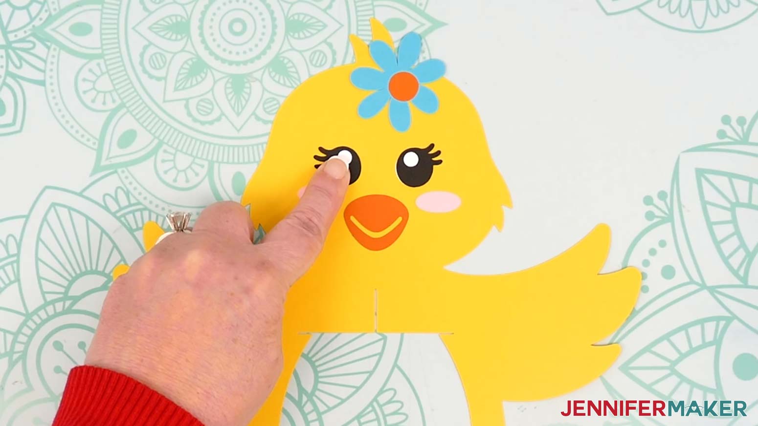 Adhere the left eye to the chick lantern's face with the eyelashes pointing to the left.