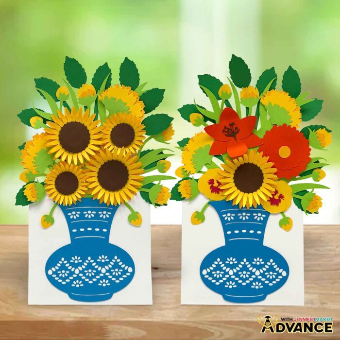 Make an Easy 3D Bouquet Card! Two cardstock flower bouquet cards sit side by side, one with sunflowers and one with a mix of yellow, orange, and red blooms, both in an intricate blue paper vase with a built-in stand