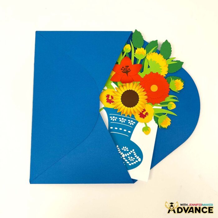 A custom Easy 3D Bouquet Card peeks out of a blue envelope. The card features sunflowers and a mix of red and orange additional flowers