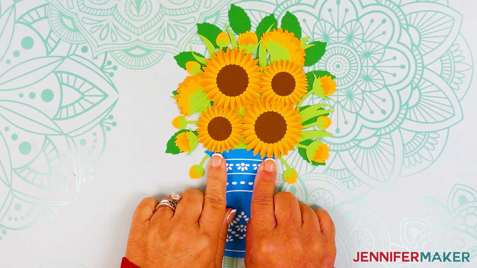 The vase is being glued to the bouquet layer underneath the overlapping flowers to create depth.