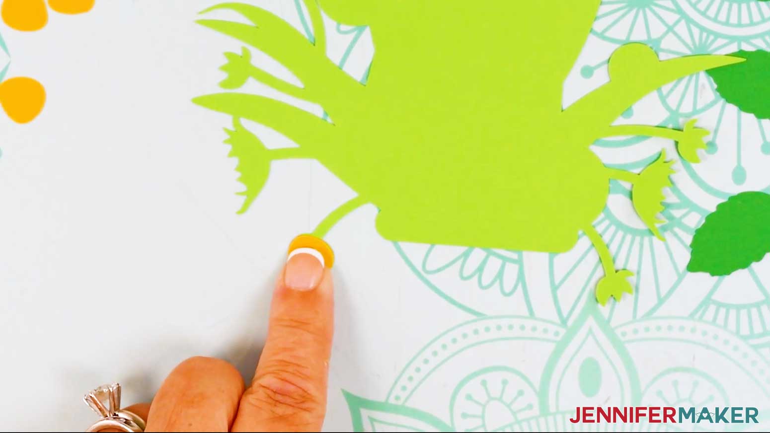 The light green foliage layer of the bouquet card is shown laying the backside up and a small yellow bud is glued to the small sepal.