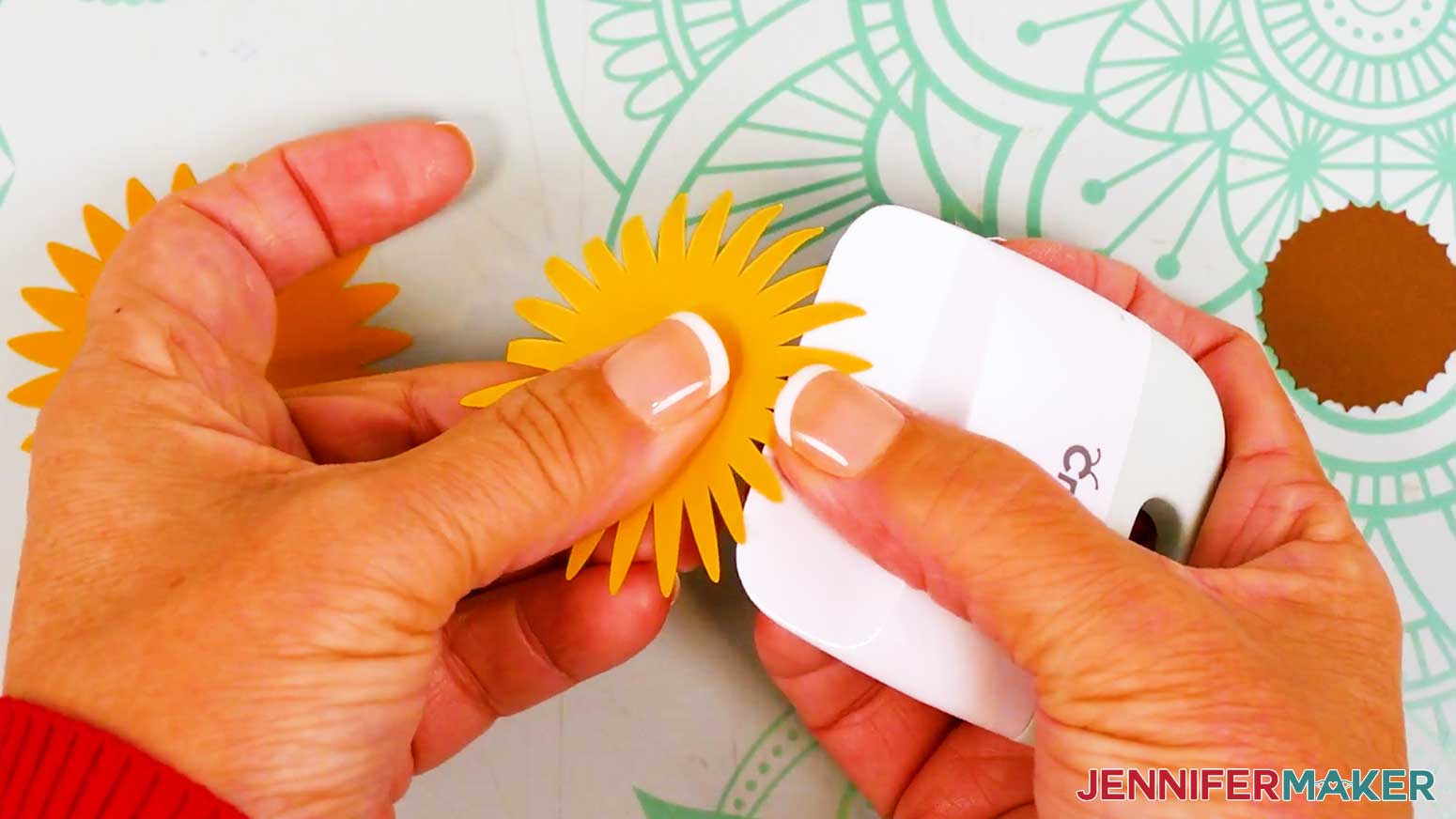 The large sunflower petal front piece is held in the hand and a scraper or bone folder is used to curl the petals upwards.