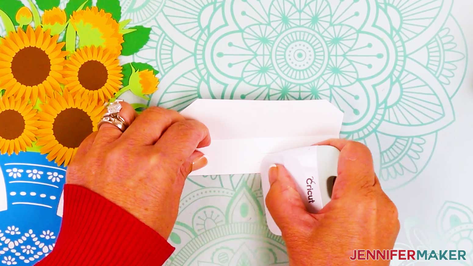 The tab is being creased with a scraper to fold up towards the middle fold of the inner card stand.