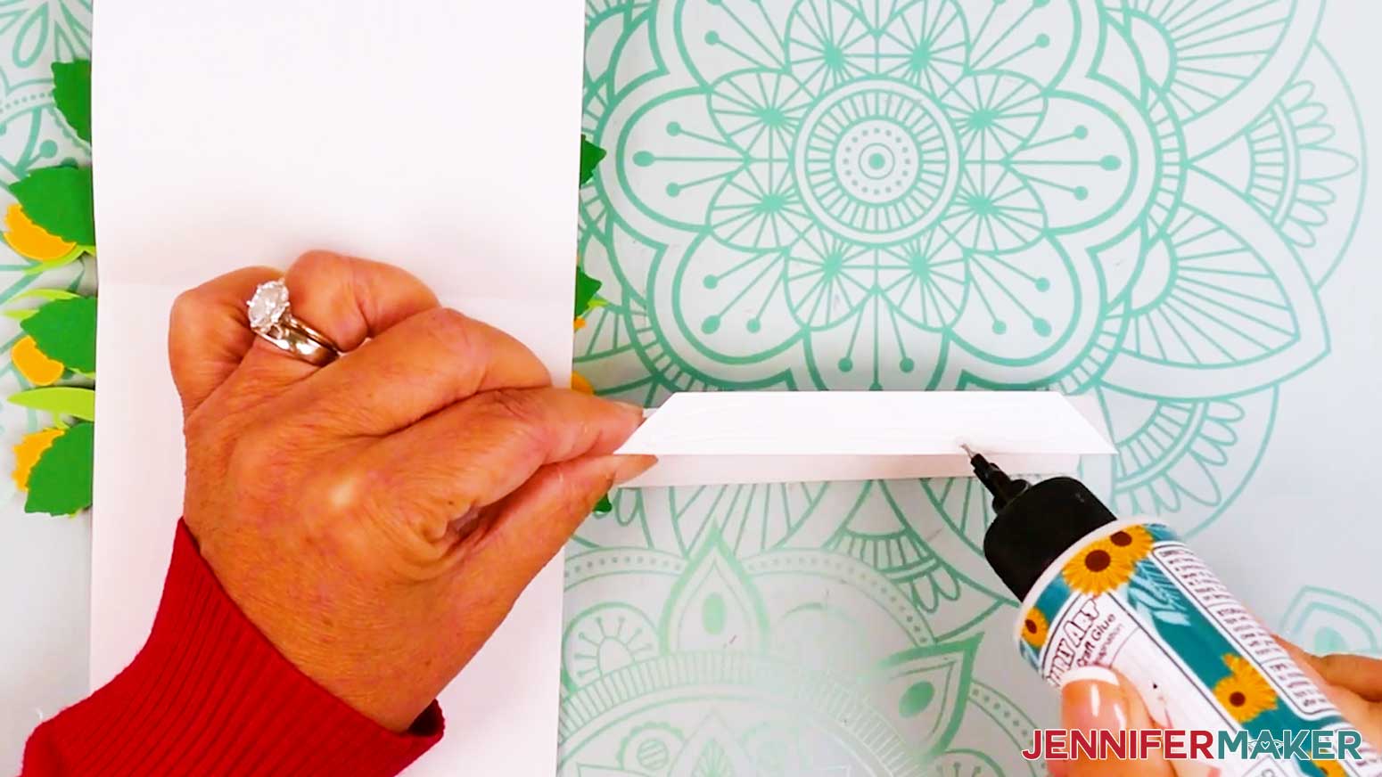 All the folds have been made and glue is being applied to one of the tabs of the inner card stand.