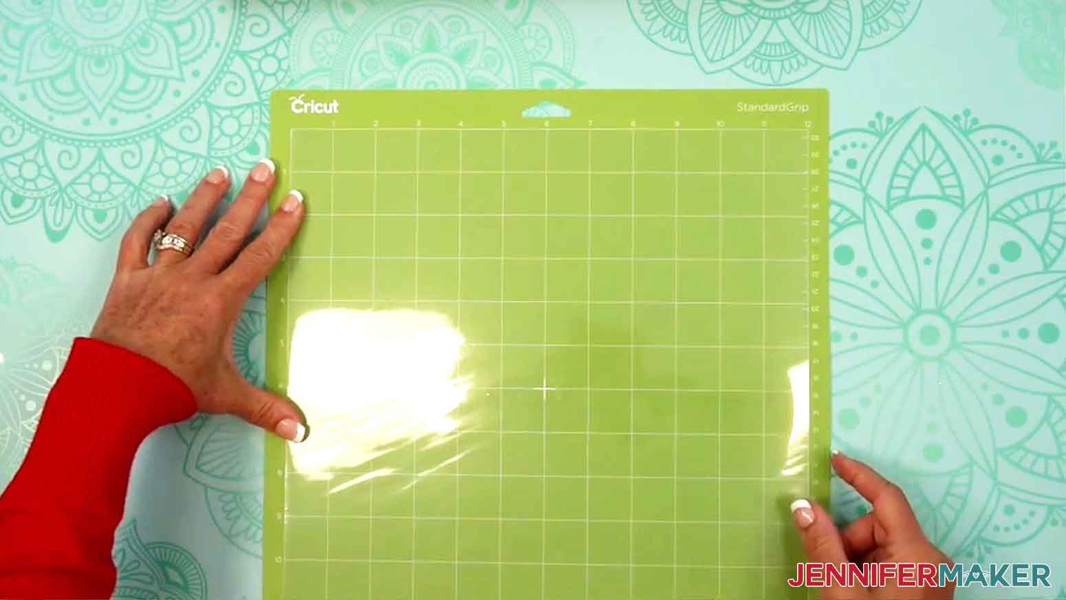 The acetate is being placed on the Cricut standard green mat.