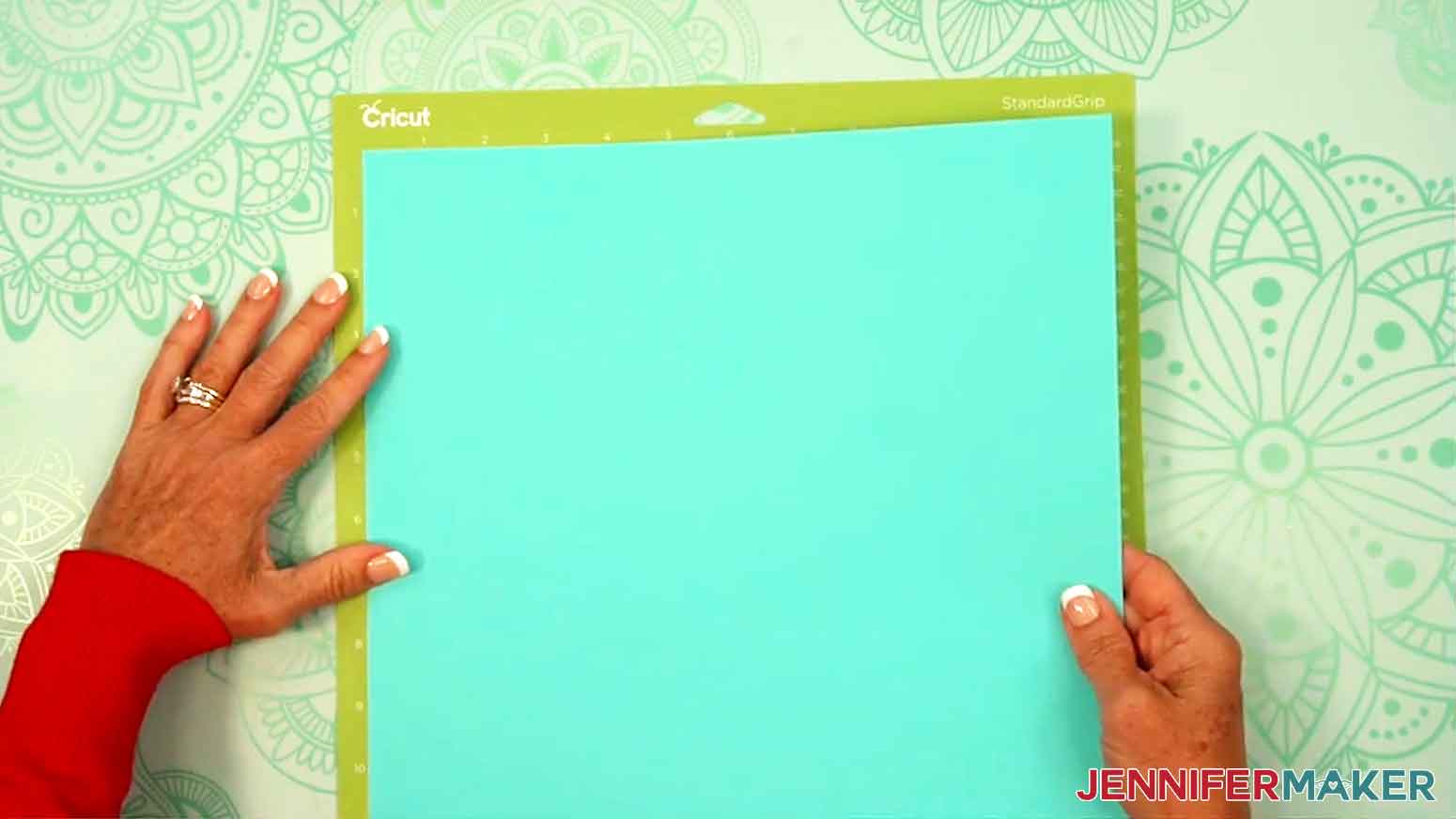 The cardstock is being applied to the Cricut Standard grip green mat.
